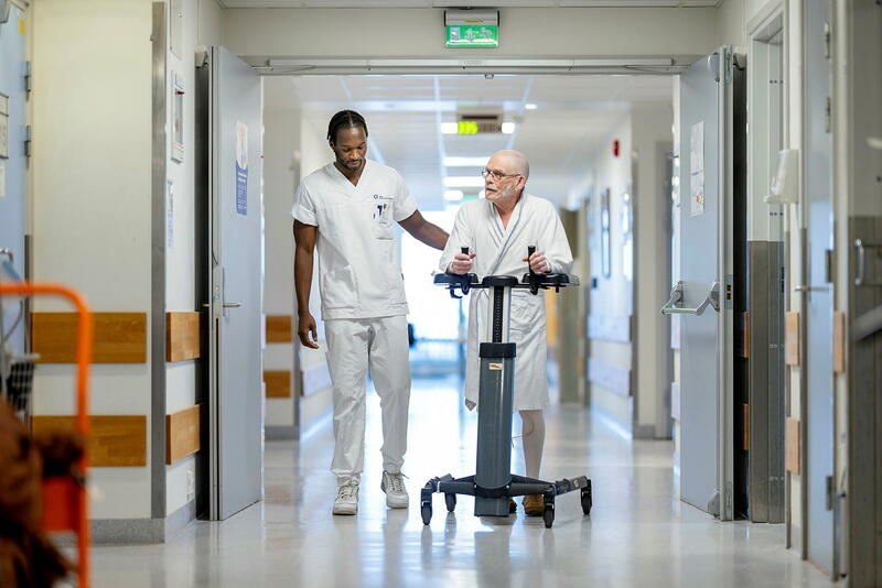 Sykepleier og pasient i korridor